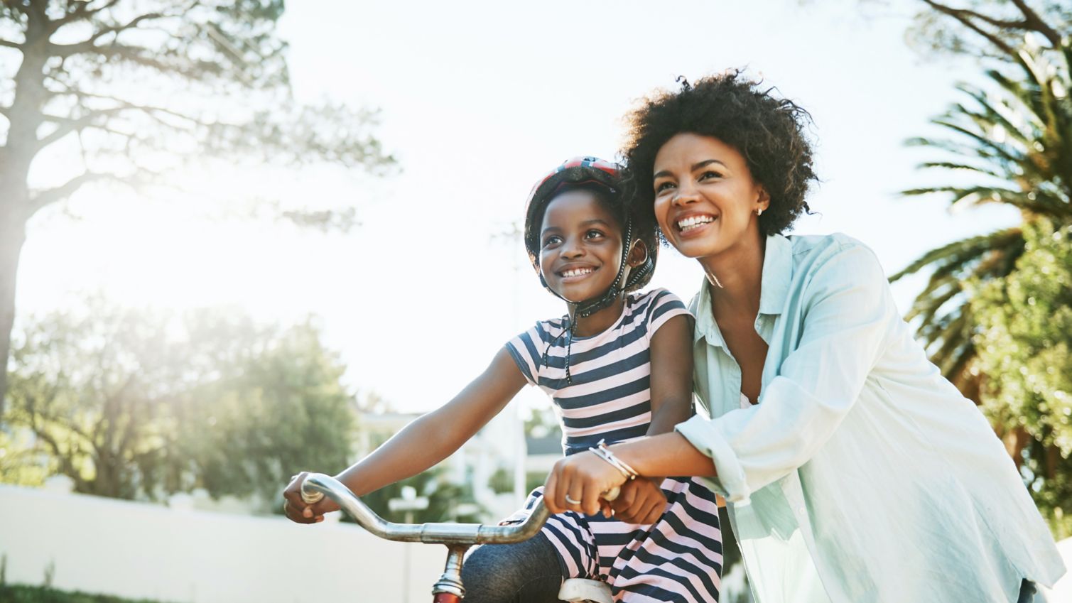 Mom helps daughter ride a bike